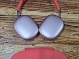 pair of pink and silver headphones on a wooden table