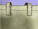 the green purse is sitting on the table with a purple background