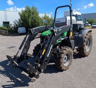 le tracteur est garé sur le parking, l'arrière de son chargeur