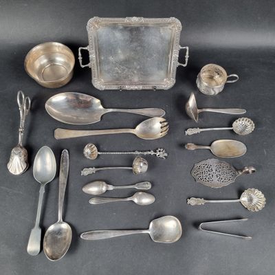 a lot of silver spoons and other silverware on a table