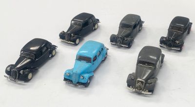plusieurs petites voitures sont alignées sur une surface blanche