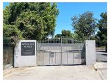 le portail d'entrée d'un parc sur lequel est accrochée une pancarte