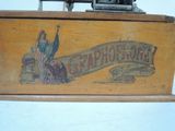 a wooden box with a sign on it and a sewing machine in the background