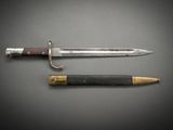 an old knife and a pencil sitting on top of a table