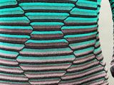 an image of a woman wearing a green and black striped sweater