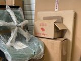 many boxes that are sitting on the floor next to a chair
