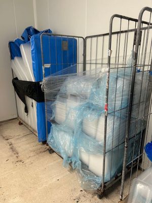 une cage métallique remplie de récipients en plastique et d'un récipient bleu