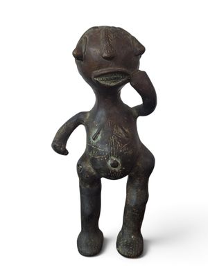 figurine in the form of a man with a hat on his head and hands on his head