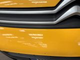 the front end of a yellow car with a black bumper
