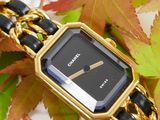 an image of a gold and black watch sitting on top of a pile of leaves