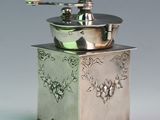 a silver coffee grinder sitting on top of a table
