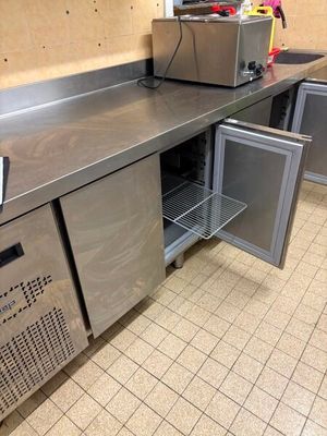 une cuisine équipée de plans de travail et d'armoires en acier inoxydable