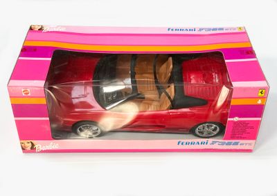 une petite voiture rouge dans une boîte rose posée sur une surface blanche