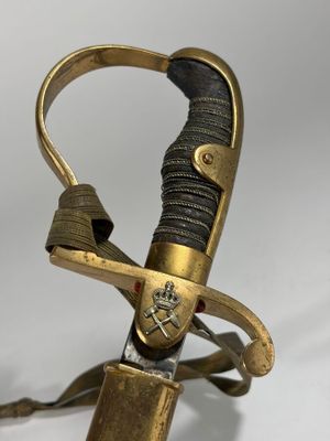 une épée avec une poignée en or sur une surface blanche