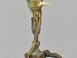 bronze statue of a woman holding a lamp with a bird perched on her head
