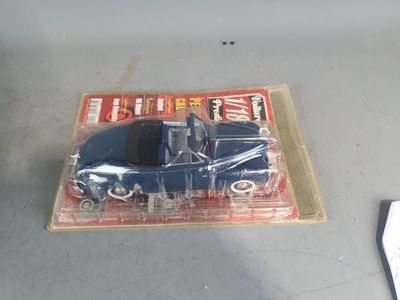a blue toy car in a plastic package on a table
