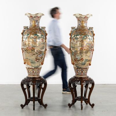two large vases sitting on pedestals in the middle of a room