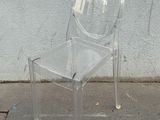 une chaise en plastique transparent posée au bord de la rue