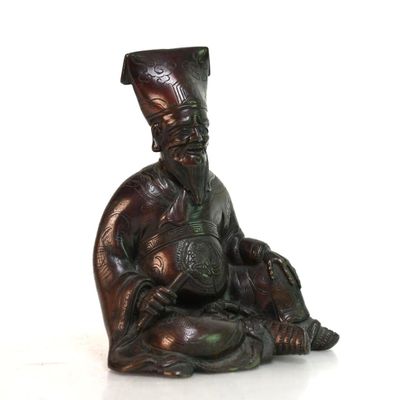une statue en bronze représentant un homme assis par terre