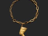 a gold bracelet with an egyptian head charm on it