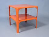 une table d'appoint orange surmontée d'une étagère