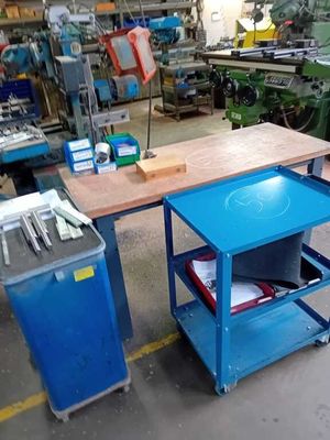 une table avec un plateau bleu et un chariot bleu contenant des outils