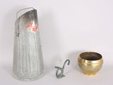 a silver pitcher and a gold cup next to each other