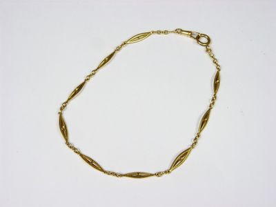 a close up of a gold bracelet on a white surface