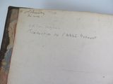 an old book with writing on it sitting on top of a table