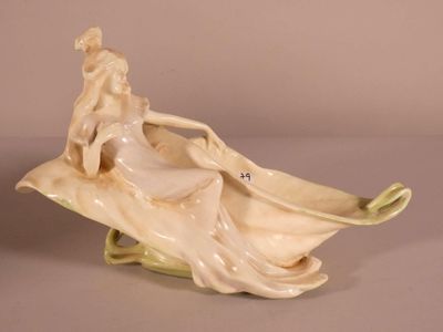 a figurine of a woman sitting on a leaf