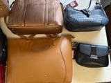 many bags and purses on a table in a room