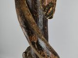 a hand that is holding a piece of wood with a snake on it