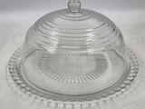 un plat à gâteau en verre muni d'un couvercle bombé