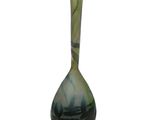 a green and black vase sitting on a white surface