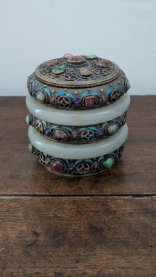 three stacked bangles with multi colored stones on a wooden table