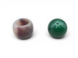 deux perles vertes et marron sur un fond blanc