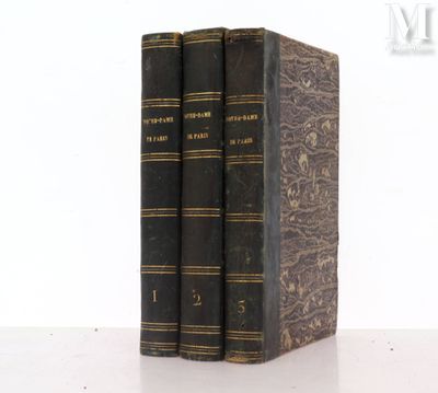 two old books sitting on top of each other on a table