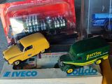 trois camions miniatures qui se trouvent dans une boîte