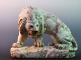 a statue of a dog that is sitting on a rock