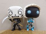 two figurines of a skeleton and a skeleton with a baseball bat