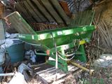une machine verte posée à côté d'un tas d'ordures