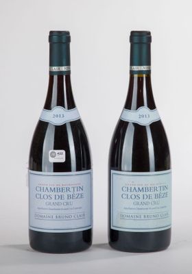 deux bouteilles de vin posées l'une à côté de l'autre sur une surface blanche