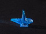 a blue glass bird sitting on a black surface