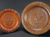 two brown plates with a lion head on them on a black background