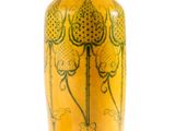 un vase jaune posé sur une surface blanche, avec un fond blanc