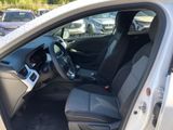 the interior of a car with the door open and the driver ' s seat down