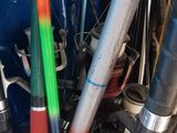 une pile de battes de baseball de différentes couleurs