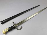 an old sword with a wooden handle sitting on top of a table