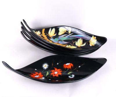 deux assiettes noires ornées de fleurs et de feuilles sur un fond blanc
