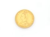 a close up of a gold coin on a white surface